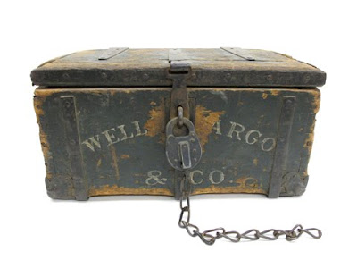 An antique iron-chained Wells Fargo strongbox representing historical wealth transport.