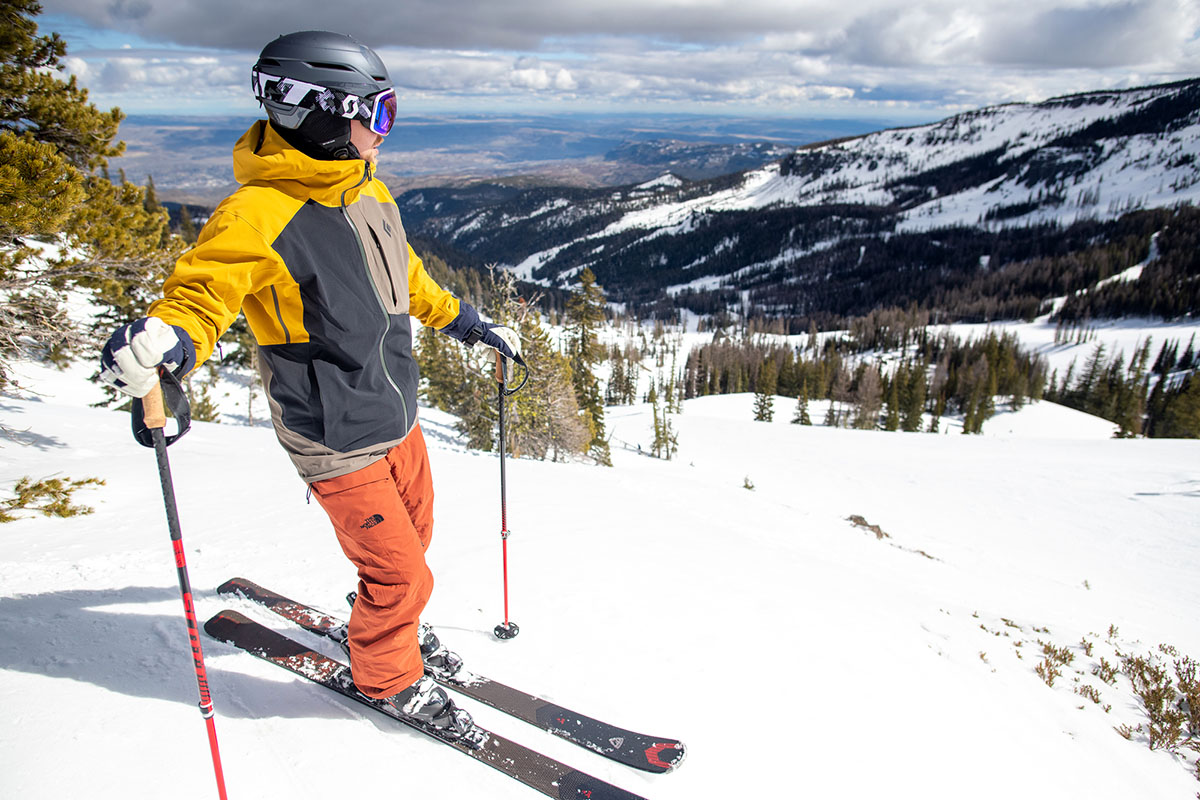 A man standing at the top of a ski run wearing The North Face Freedom insulated pants.