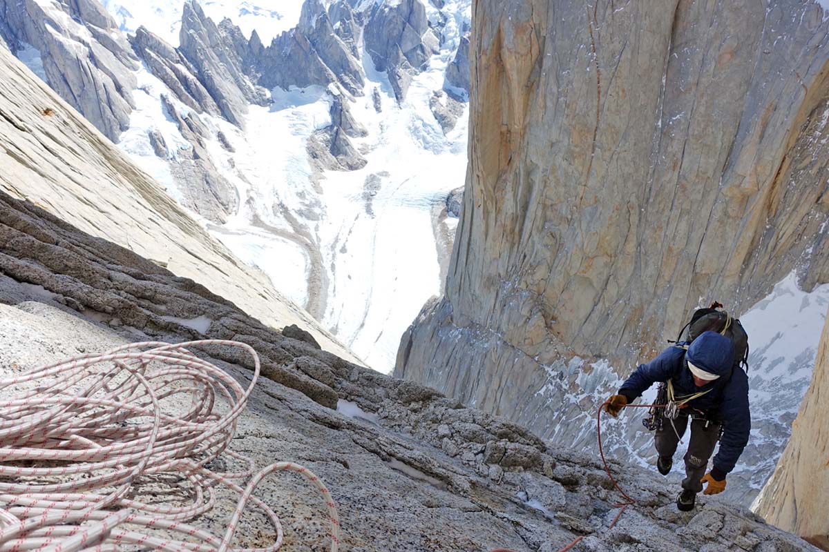 A climber navigating an alpine ridge in a Patagonia DAS Light Hoody.