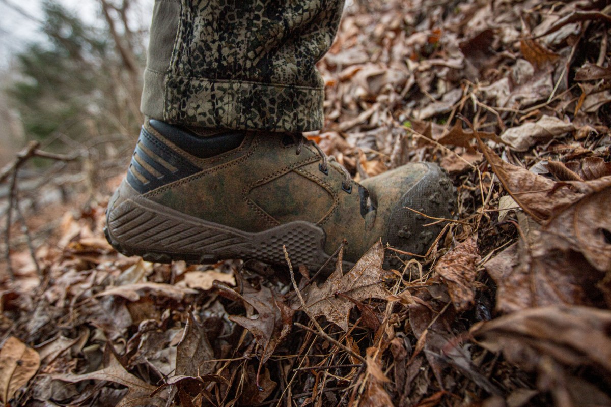 A hunter walking uphill to test the flexibility of his boots.