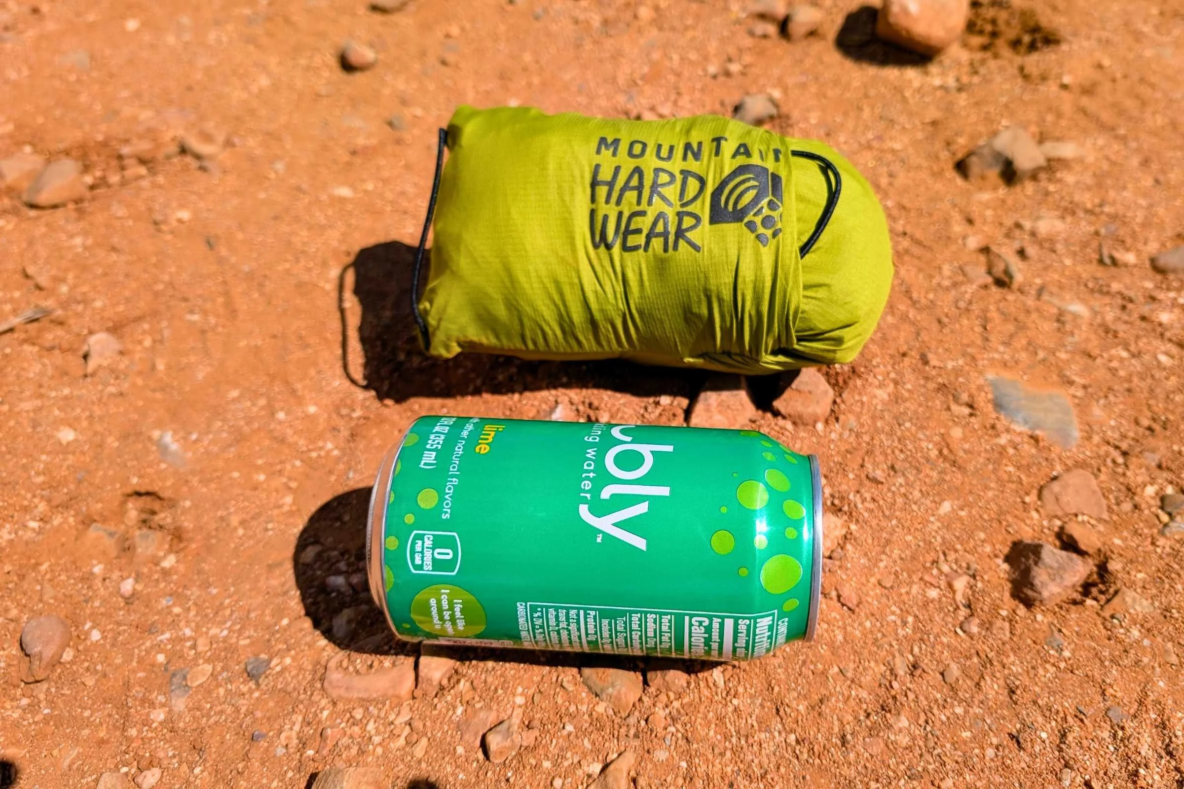 A Mountain Hardwear Kor Airshell jacket stuffed into its own pocket next to a soda can for size comparison.