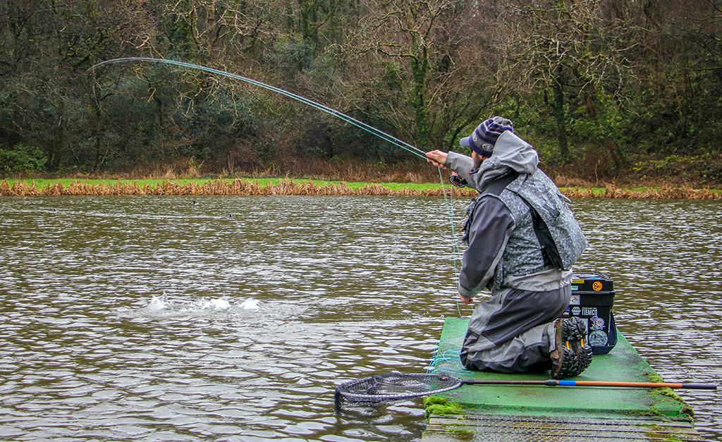 A trout being landed using a floral indicator or 'bung' rig setup.