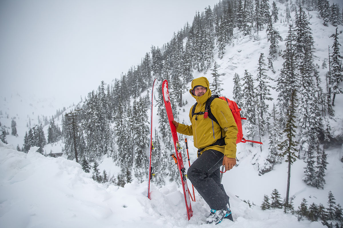 A man standing on skis in deep snow wearing the Arc'teryx Sabre Pant.