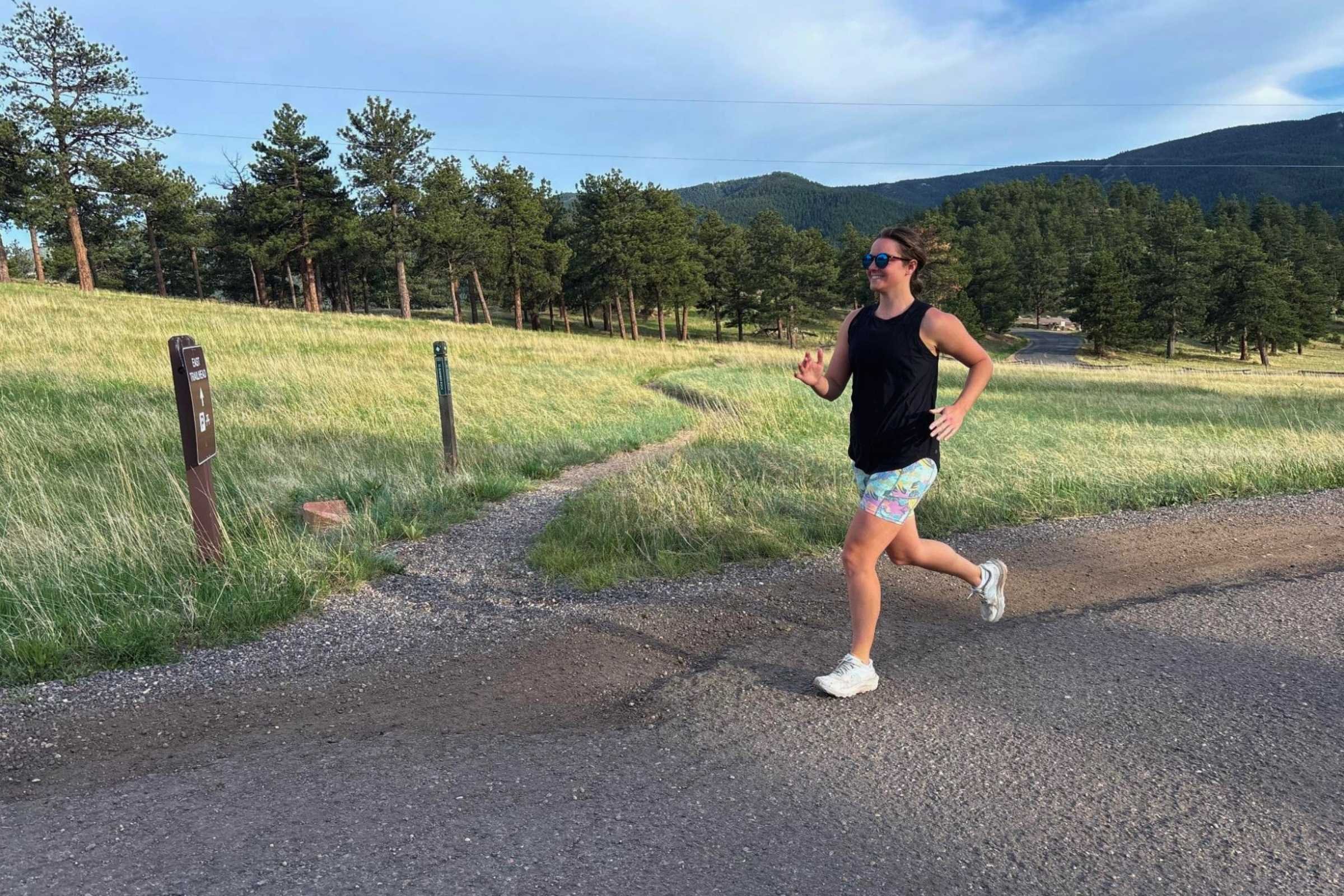 A woman wearing black Patagonia Maipo running shorts showing the high-rise waistband and mid-thigh length.