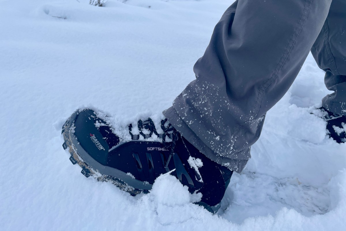 Baffin Zone winter hiking boots held up against a cold, snowy landscape.