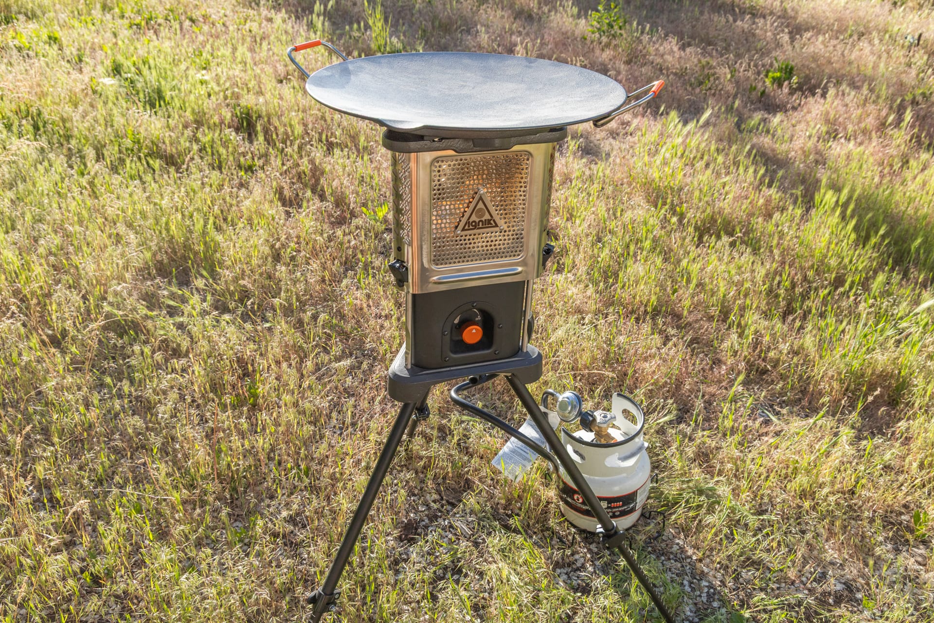 Ignik Skullet set up with tripod legs and the skillet ready to cook on a wooden table.