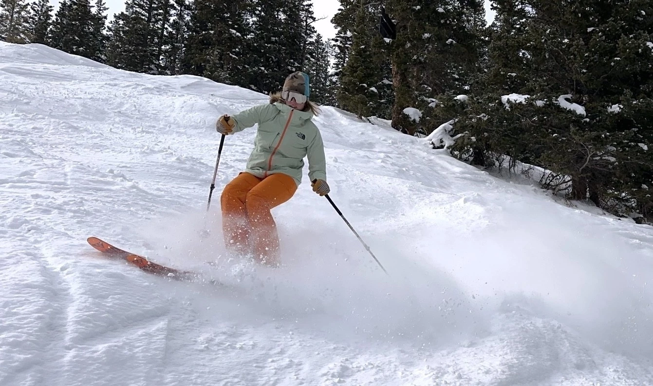 Skier wearing a purple The North Face Triclimate jacket on a mountain.