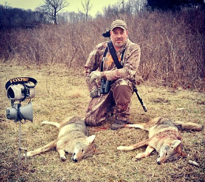 Hunter Corey Groff posing with several harvested coyotes after a successful hunt.