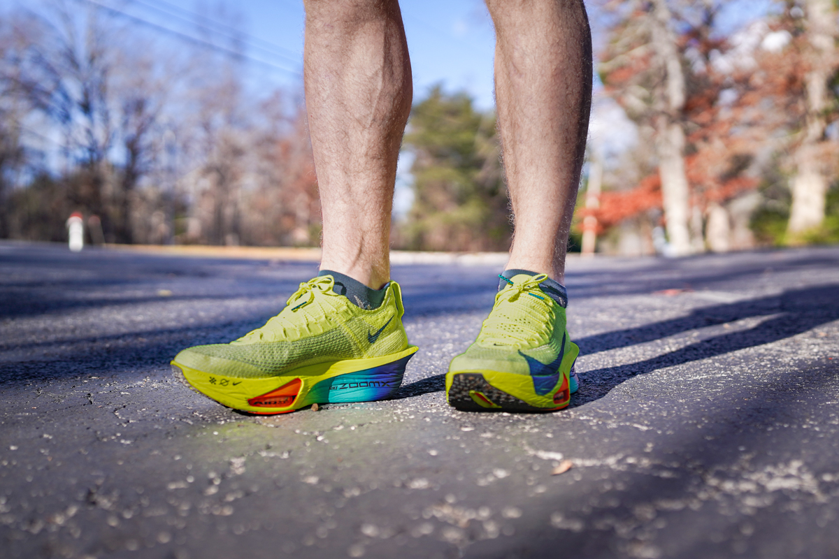 A close-up of a runner's feet wearing the Nike Alphafly racing shoes during a high-speed run.