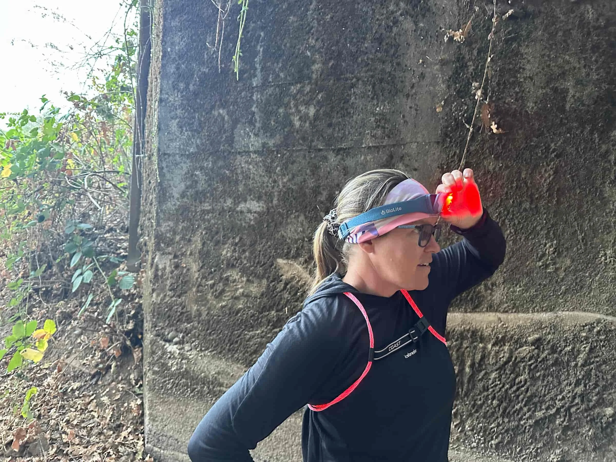 A runner wearing both a bright headlamp and a multi-color lighted safety vest.