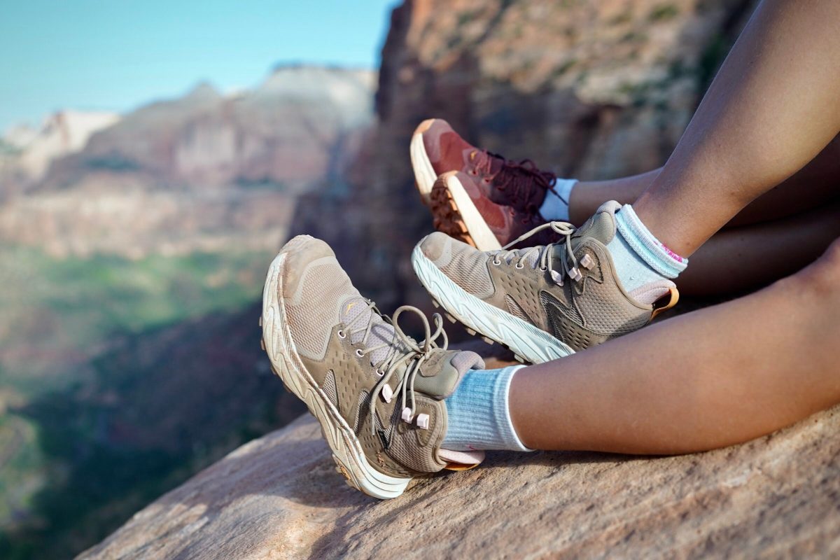 A hiker's boots partially submerged in a shallow mountain stream to test water resistance.