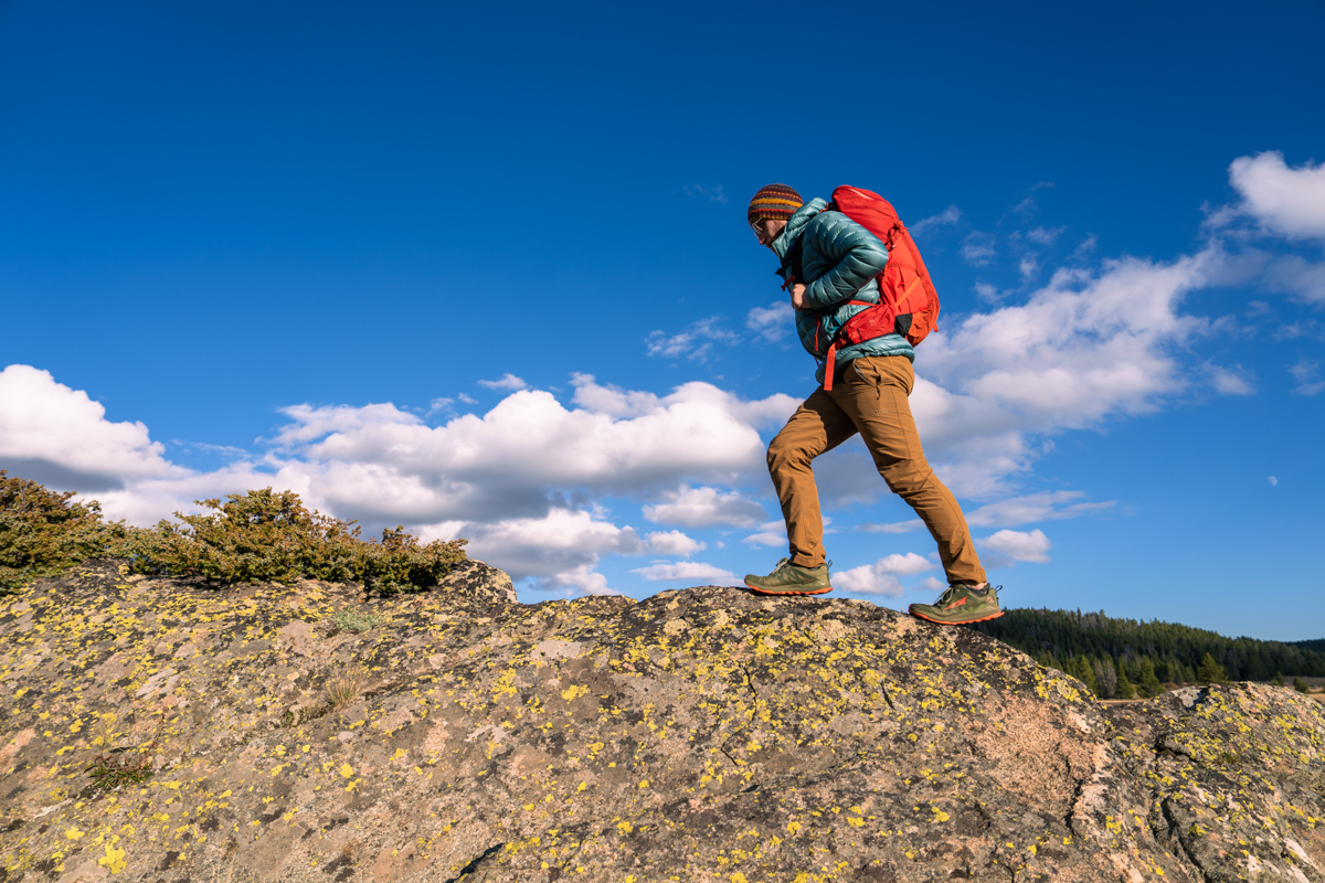 A hiker traversing a rocky mountain ridge in Wyoming wearing Altra Lone Peak hiking boots.
