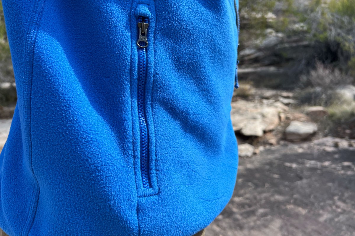 A person standing outdoors showing the full front view and relaxed silhouette of the fleece jacket.