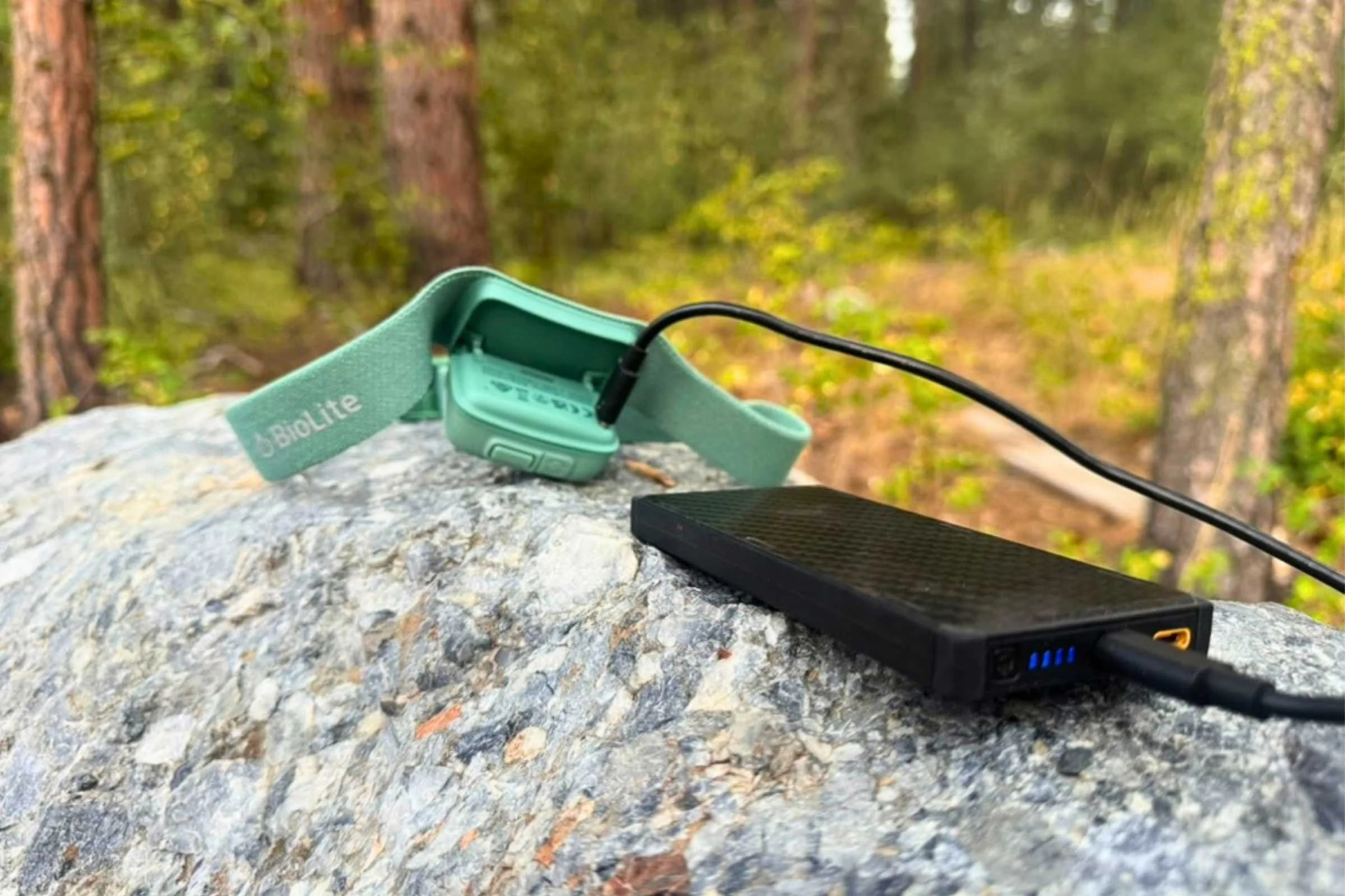 Smartphone and power bank tucked into the pocket of a down jacket for insulation.