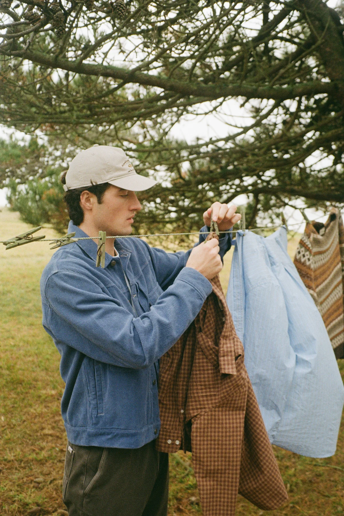 Forét clothing hanging on an outdoor clothesline against a natural backdrop.