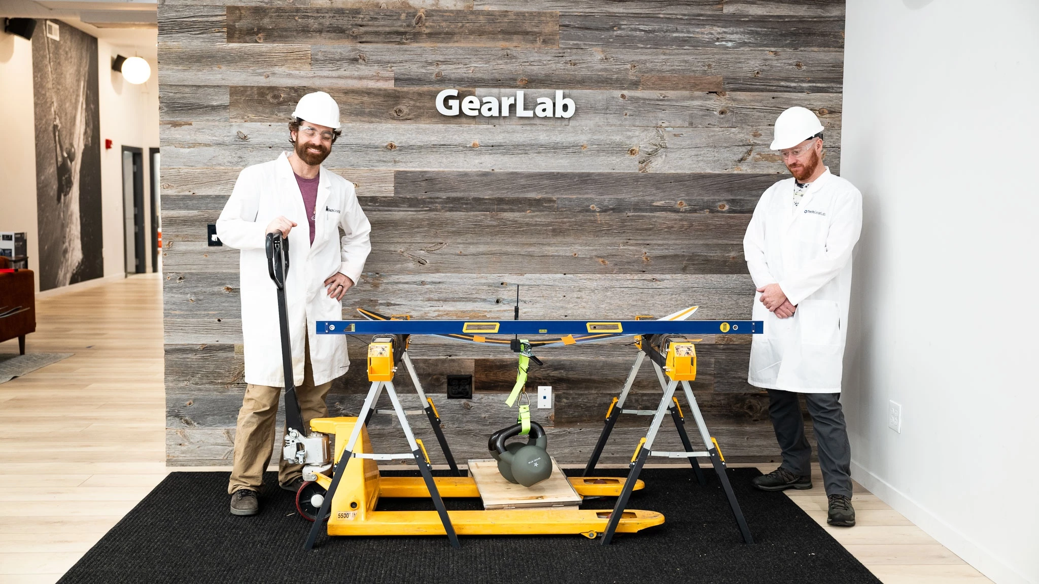 A technician measuring the technical specifications of a snowboard on a table.