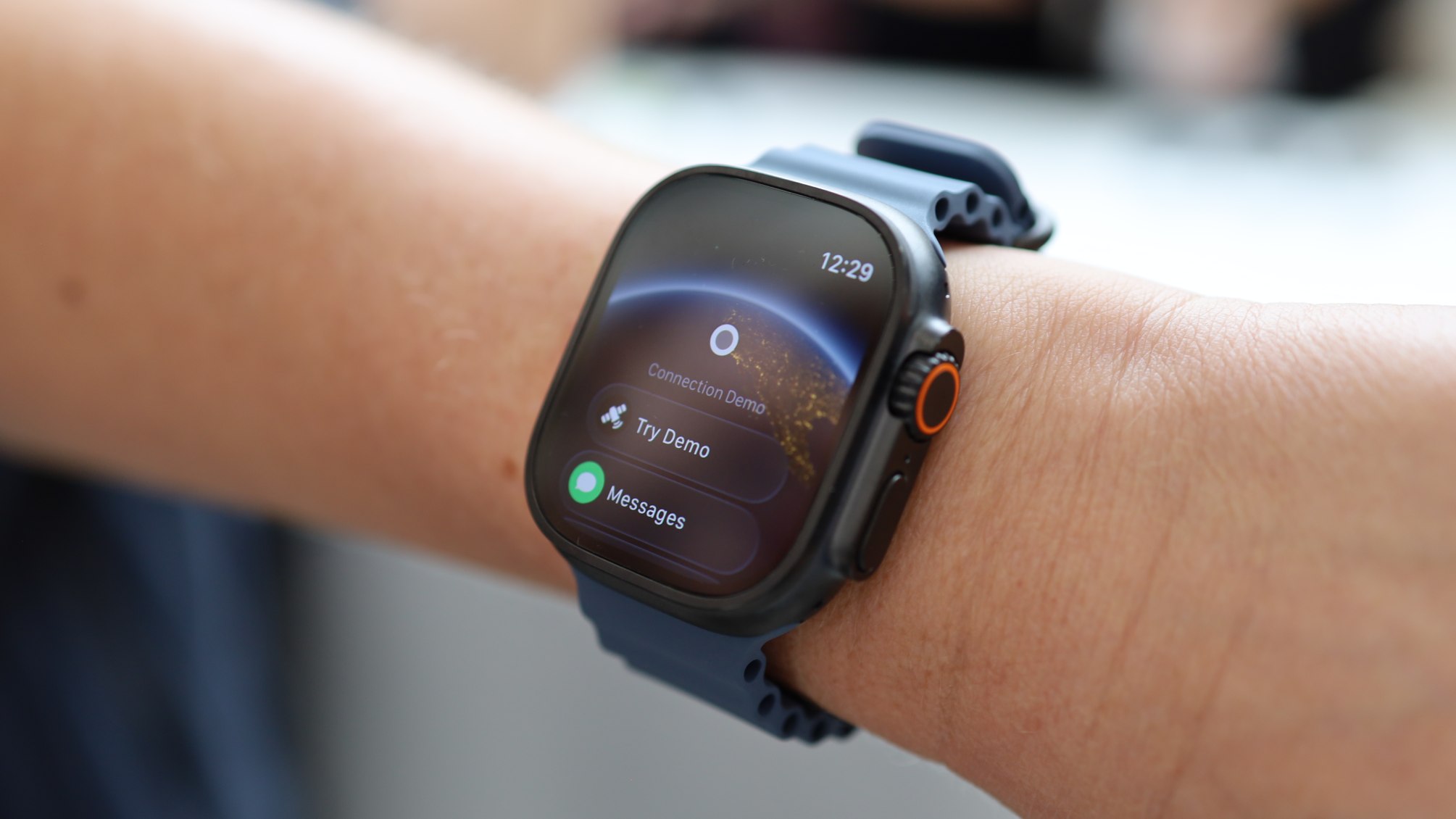 Apple Watch Ultra 3 with titanium casing and a rugged orange ocean band.