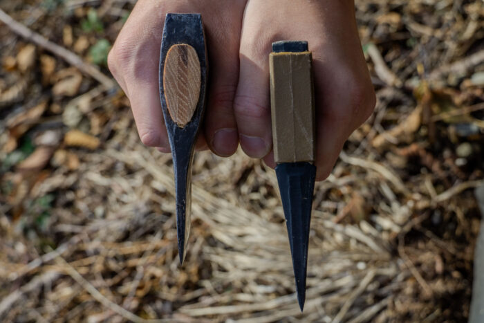 A side-by-side comparison of different axe bit profiles on a wooden surface.